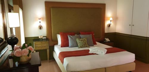 a bedroom with a large bed with red pillows at Villa Foscarini Cornaro in Gorgo al Monticano