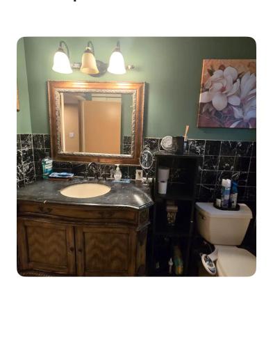 a bathroom with a sink and a mirror and a toilet at Charming relaxed staying in Sacramento