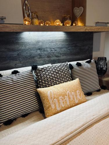 a group of pillows on a bed with a shelf at Luxury Cozy Caravan at Seaton Sands in Port Seton