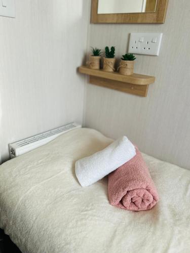 a towel sitting on a bed in a bedroom at Luxury Cozy Caravan at Seaton Sands in Port Seton
