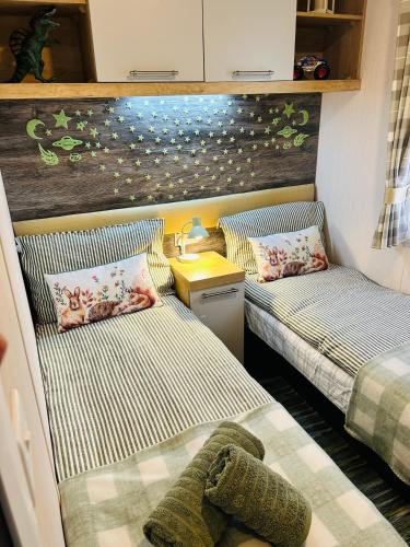 two beds in a small room with two bedsskirts at Luxury Cozy Caravan at Seaton Sands in Port Seton