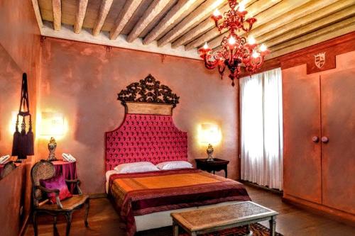 a bedroom with a large bed with a red headboard at Villa Foscarini Cornaro in Gorgo al Monticano