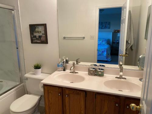 Un baño con lavabo, inodoro y espejo. en Cozy 3 bedrooms towhouse, en Frederick