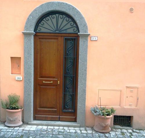 a wooden door on a building with two potted plants at Apartment Castel Gandolfo in Castel Gandolfo