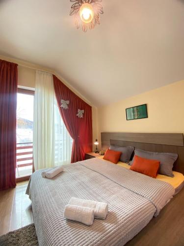 a bedroom with a large bed with two towels on it at Villa Sun Valley in Bakuriani
