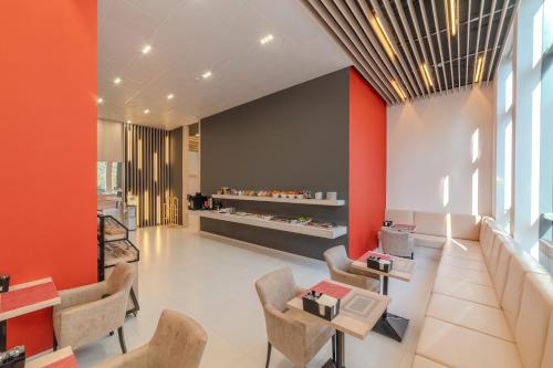 a restaurant with orange walls and chairs and tables at Duo Hotel by Futuro in Bishkek