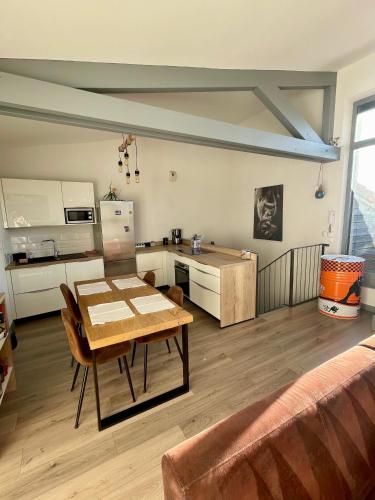 un salon avec une table et une cuisine dans l'établissement Appartement en duplex avec terrasse, à Saint-Étienne