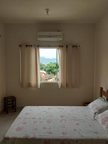 a bedroom with a bed and a window at Suítes XIBAYKA in Ilhabela