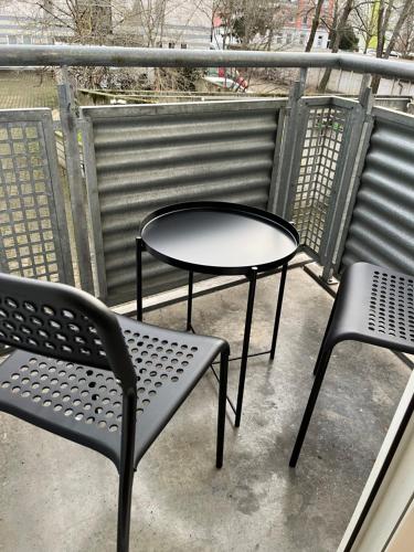 a table and two chairs sitting on a balcony at Studio an der Elbe mit Balkon, Küche und Netflix in Dresden