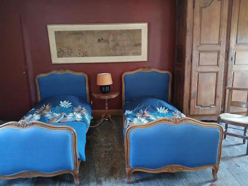 two blue chairs in a room with a table at Aile de la Maison de Chouliou in Balaguères