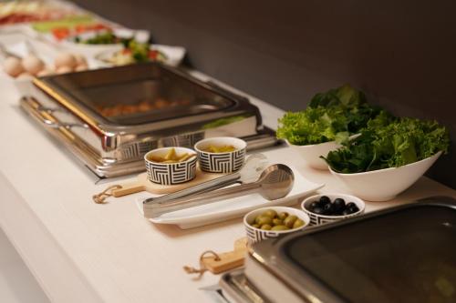 a table with a buffet of food and vegetables on it at Duo Hotel by Futuro in Bishkek