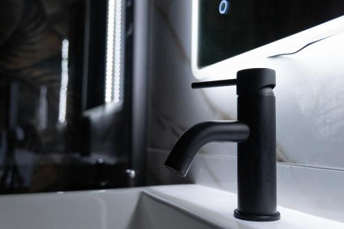 a black water faucet in front of a tv at V&V art & rooms in Nocera Inferiore