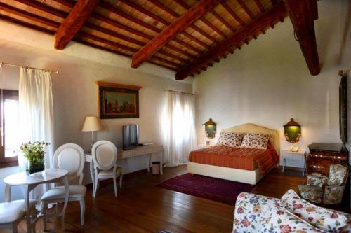 a bedroom with a bed and a table and chairs at Villa Foscarini Cornaro in Gorgo al Monticano