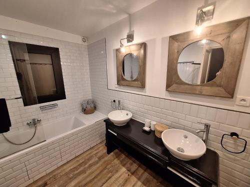 La salle de bains est pourvue de 2 lavabos, d'une baignoire et d'un miroir. dans l'établissement BergerieMuratinca privacy piscine vue mer 16 pers - location du samedi au samedi, à Corbara