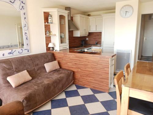 a living room with a brown couch in a kitchen at Casa Marina - Le Petit Bleu Vue mer in Pornic