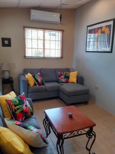 a living room with a couch and a table at Sweet Mango in Port-of-Spain