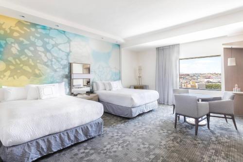 a hotel room with two beds and a large window at Courtyard by Marriott Chihuahua in Chihuahua