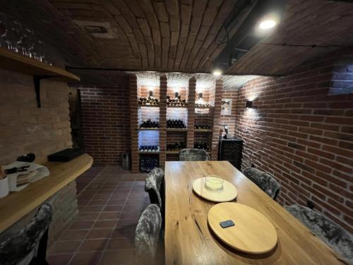a dining room with a wooden table and a brick wall at Apartmány Lednice Václavkova 206 in Lednice