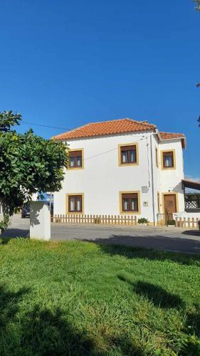 a large white building with a red roof at Na Rota - Casa de Praia in Zambujeira do Mar