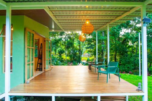 a porch of a house with chairs and a wooden deck at Quintaesencia Arte y Naturaleza in Guápiles