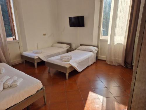 a room with three beds and a flat screen tv at Locanda Rocchetta-Premilcuore in Premilcuore