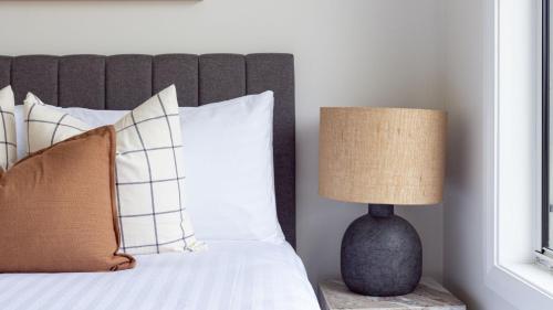 a bedroom with a bed with a lamp on a table at Misty Pond in Berrima