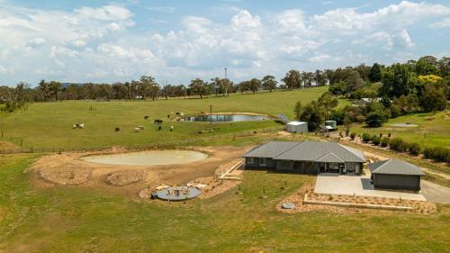 an overhead view of a farm with a building in a field at Misty Pond in Berrima