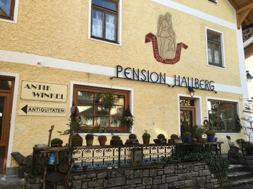 a tan building with a sign on the side of it at Pension Hallberg in Hallstatt