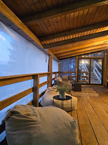 a room with two beds on a wooden deck at Cabane A-frame CeziAde Tihuta in Piatra Fantanele