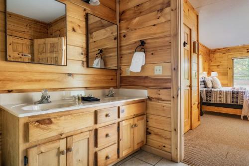 a bathroom with a sink and a mirror at Pet Friendly Family Cabin with Hot Tub & Game Room Near Dollywood in Pigeon Forge
