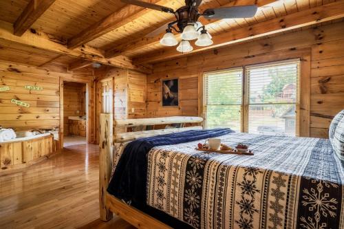 a bedroom with a bed in a log cabin at Pet Friendly Family Cabin with Hot Tub & Game Room Near Dollywood in Pigeon Forge