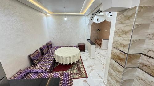 Pokój z fioletową kanapą i stołem w obiekcie Cozy place, calm and chill w mieście Tamraght Ouzdar