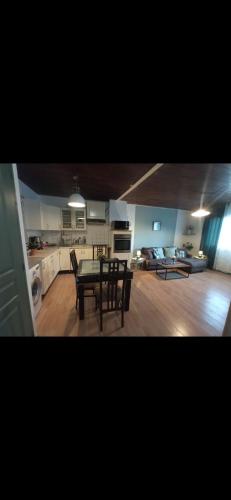 une cuisine et un salon avec une table et des chaises dans l'établissement Belle maison indépendante 3 chambres séjour à 25 minutes de Clermont-Ferrand, à La Monnerie-le Montel