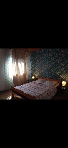 - une chambre avec un grand lit et du papier peint floral dans l'établissement Belle maison indépendante 3 chambres séjour à 25 minutes de Clermont-Ferrand, à La Monnerie-le Montel