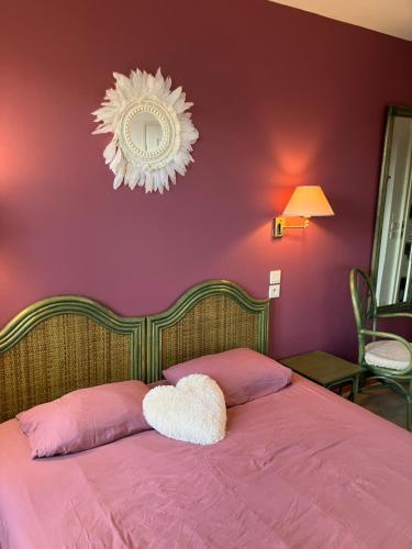 a bedroom with a bed with pink walls and a mirror at Résidence Normandie in Conches-en-Ouche