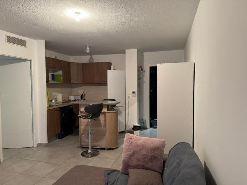 un salon avec un canapé et une cuisine dans l'établissement Studio à Louer Aiguerelles, à Montpellier