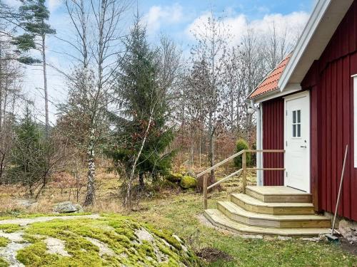 a red building with a white door and stairs next to it at 4 person holiday home in LÖNASHULT in Lönashult