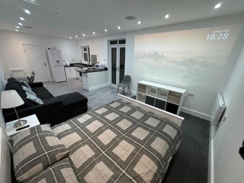 a living room with a bed and a kitchen at Private cinema studio guest house with garden in Brentwood