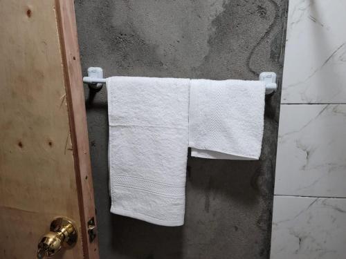 a pair of towels hanging on a towel rack in a bathroom at Deeoen Guesthouse in Kwa Dadu