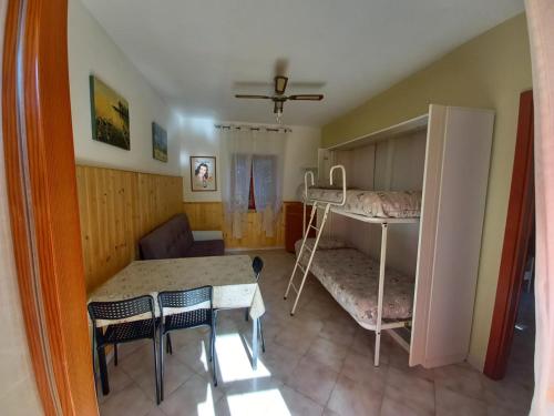 a small room with a bunk bed and a table and chairs at Villa Elena in Minturno