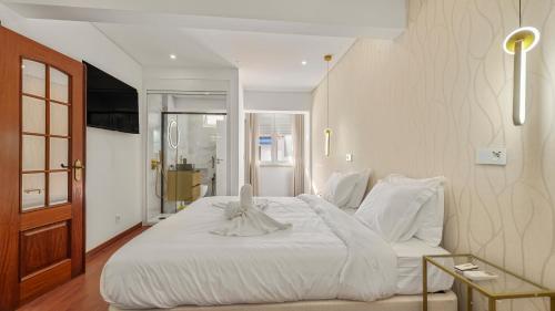 a bedroom with a large white bed with white sheets at Top Apartment in Amadora