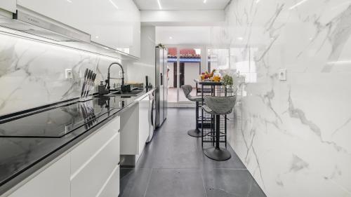 a kitchen with white marble walls and a counter at Top Apartment in Amadora