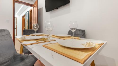a table with wine glasses and plates on it at Top Apartment in Amadora