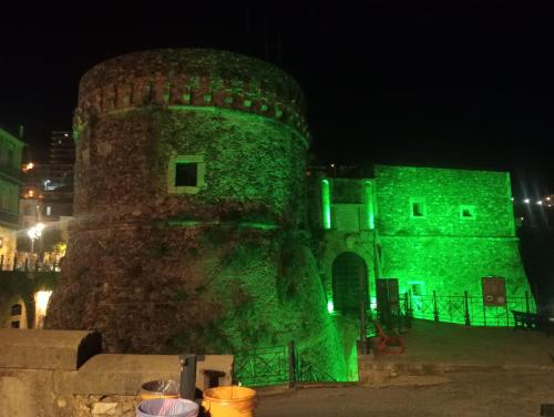 a green light projected on a castle at night at Blue House in Pizzo
