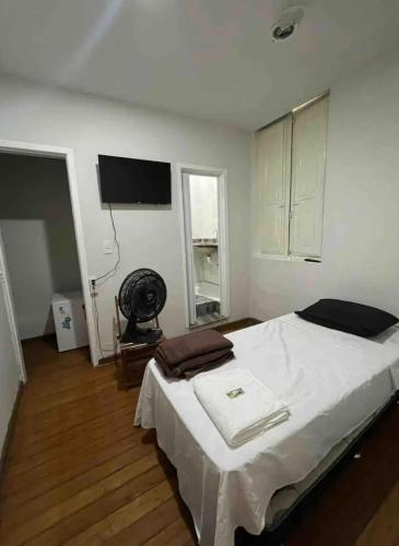 a bedroom with a large bed with a television on the wall at Suíte 102 - Pousada no Centro do Rio in Rio de Janeiro