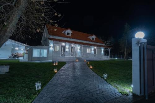 a house at night with a brick walkway in front at Tennis Home-Pozar, Piperia! in Áno Rodoniá