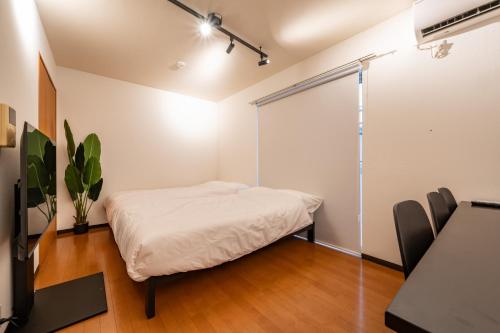 a bedroom with a bed and a sliding glass door at Willow Heim in Kawaguchi