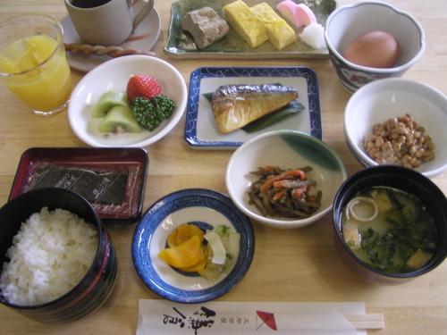 a table with plates of food and bowls of food at Uwajima Regent Hotel in Uwajima