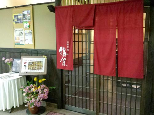 a cage with red curtains and a table and flowers at Uwajima Regent Hotel in Uwajima