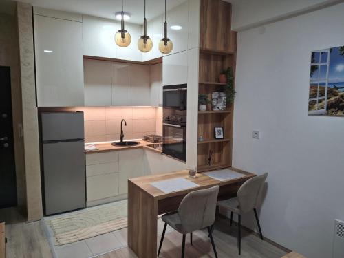 a kitchen with a table and chairs and a sink at Apartmani Marjanovic in Jagodina